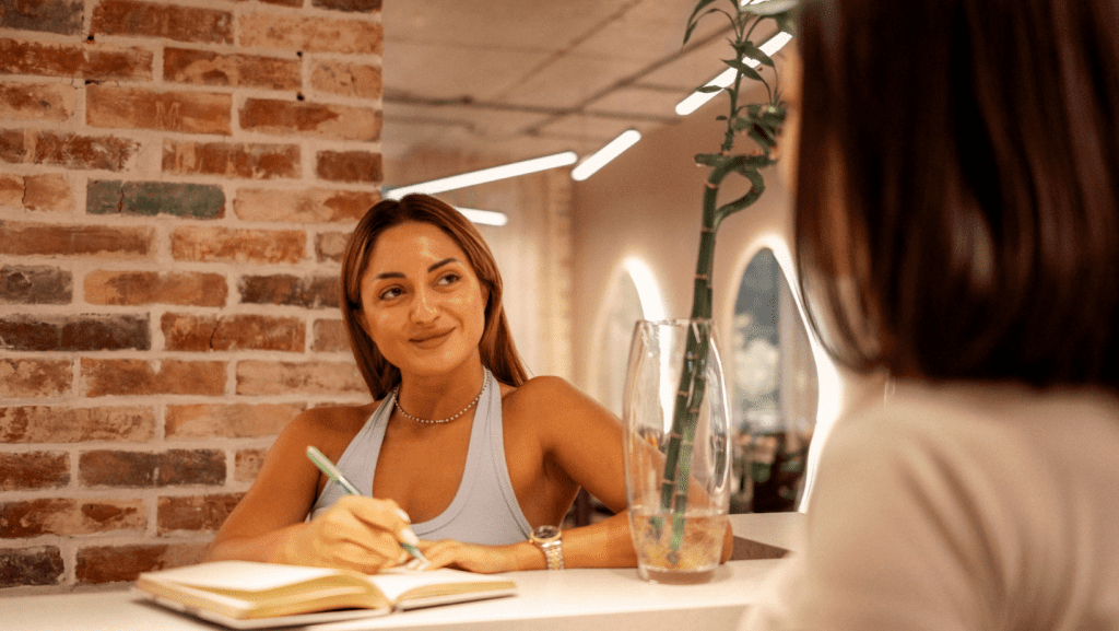 Woman in front desk welcoming a customer who booked online
